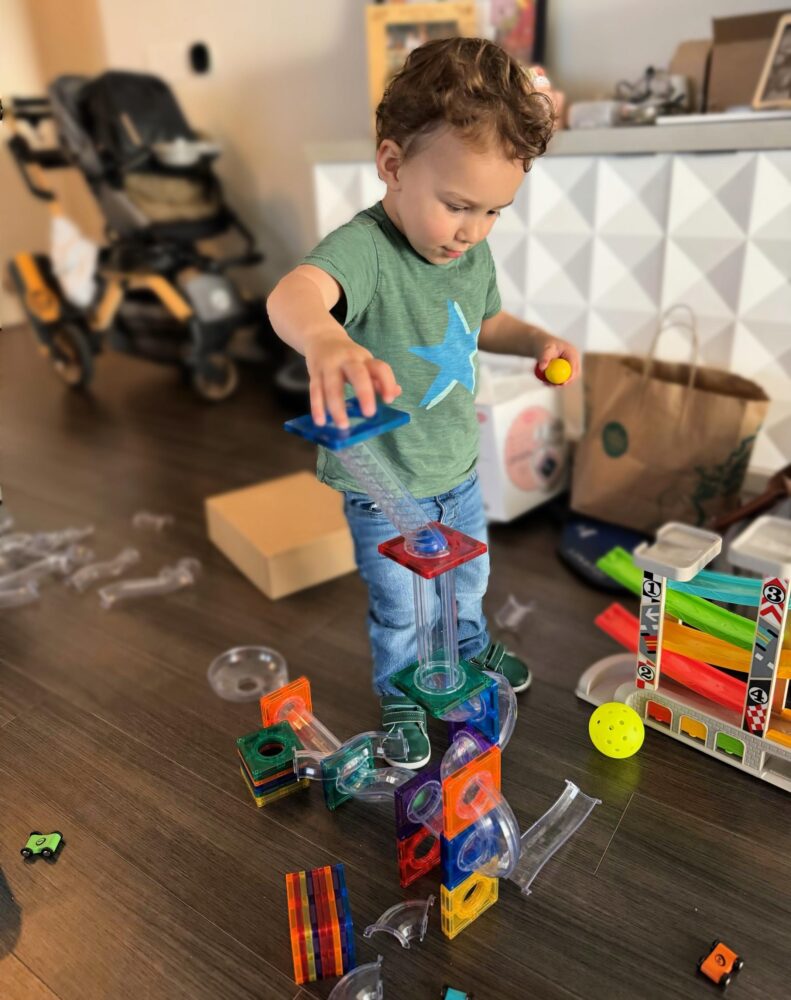 Toddler building with a marble track.